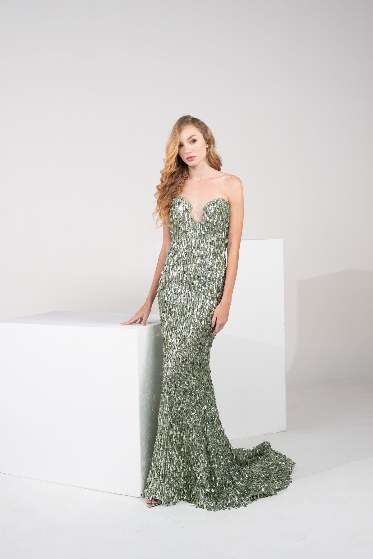 A dark green gown, fully beaded with delicate fringes from top to bottom.