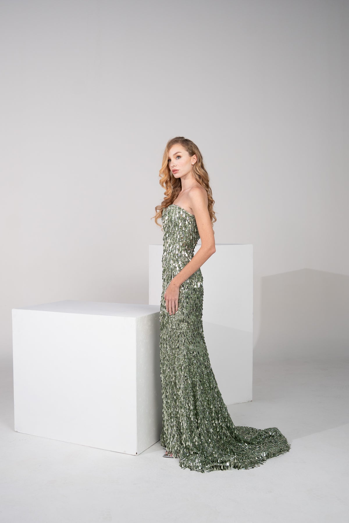 A dark green gown, fully beaded with delicate fringes from top to bottom.
