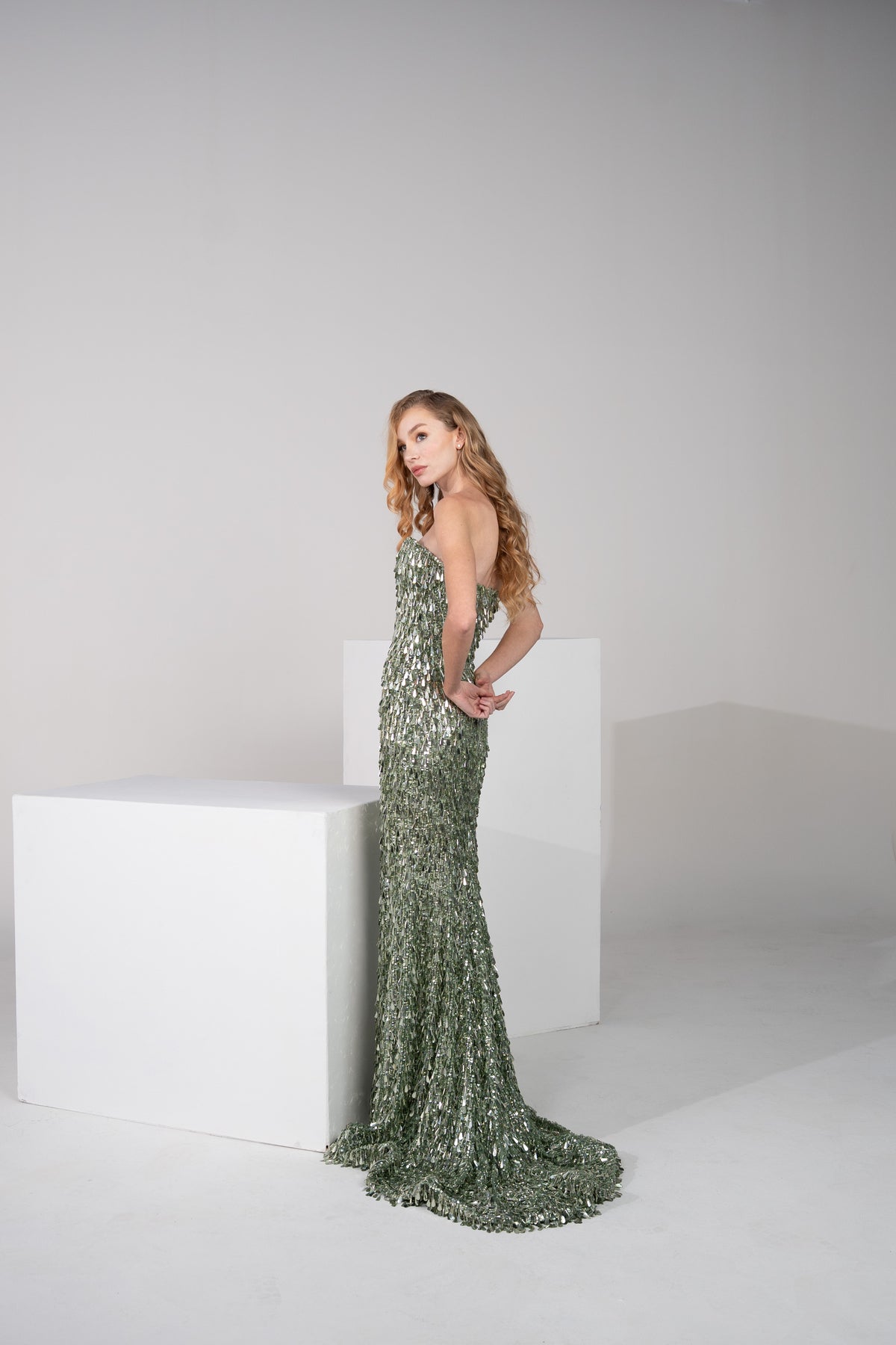 A dark green gown, fully beaded with delicate fringes from top to bottom.