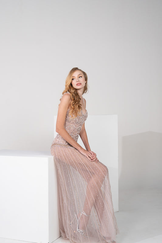A light pink beaded gown and delicate beaded lines throughout the skirt