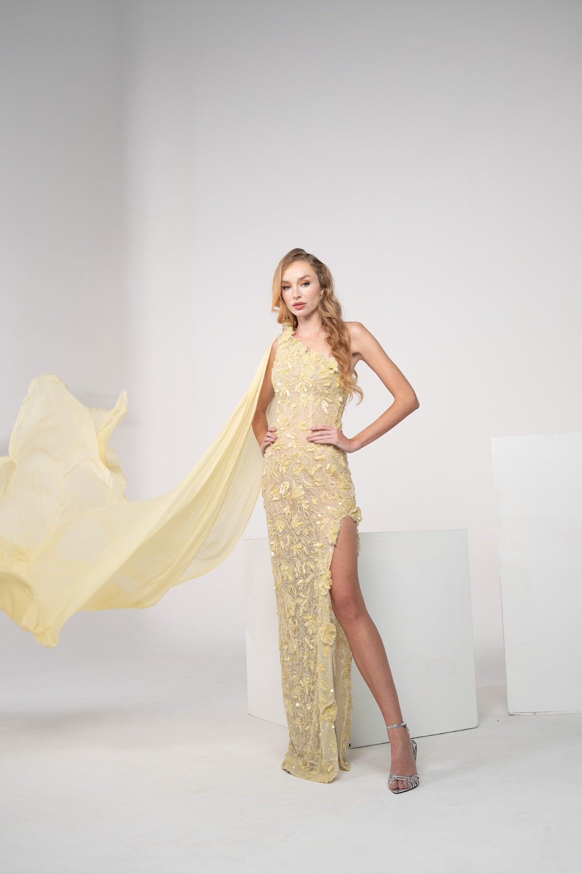 A yellow floral gown with delicate chiffon on the side and side slit.