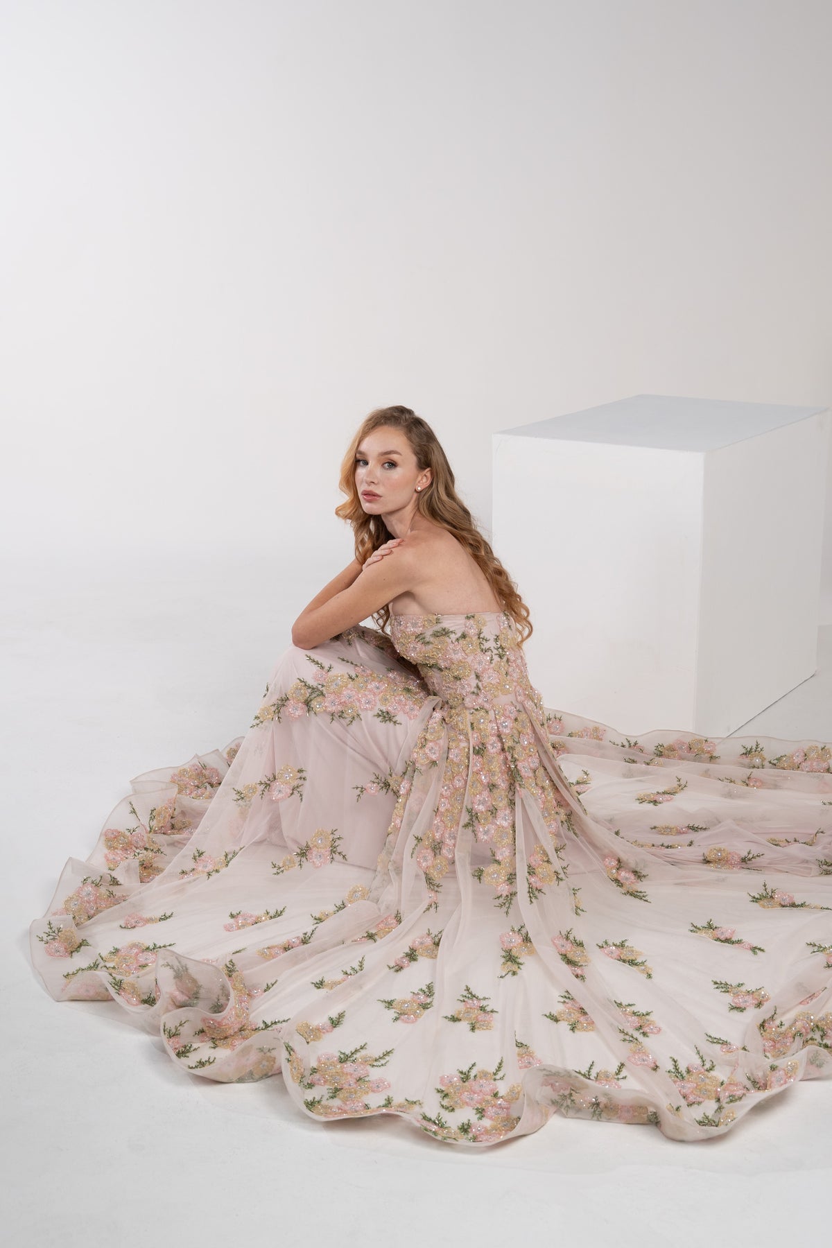 A pink puffy dress adorned with delicate pink and green flowers.