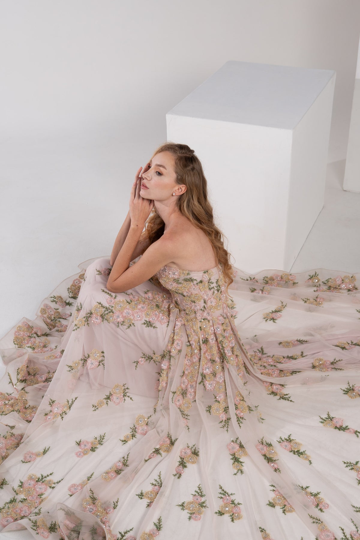A pink puffy dress adorned with delicate pink and green flowers.