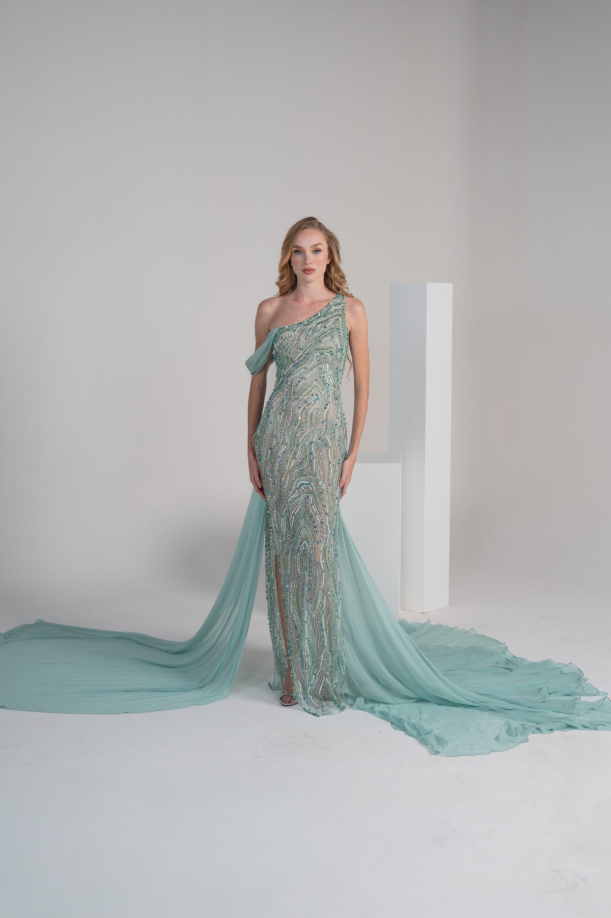 A green dress with intricate embroidery, a side slit and a flowing chiffon shwal.