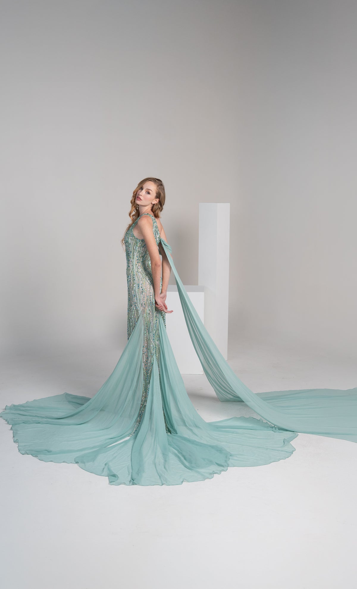 A green dress with intricate embroidery, a side slit and a flowing chiffon shwal.