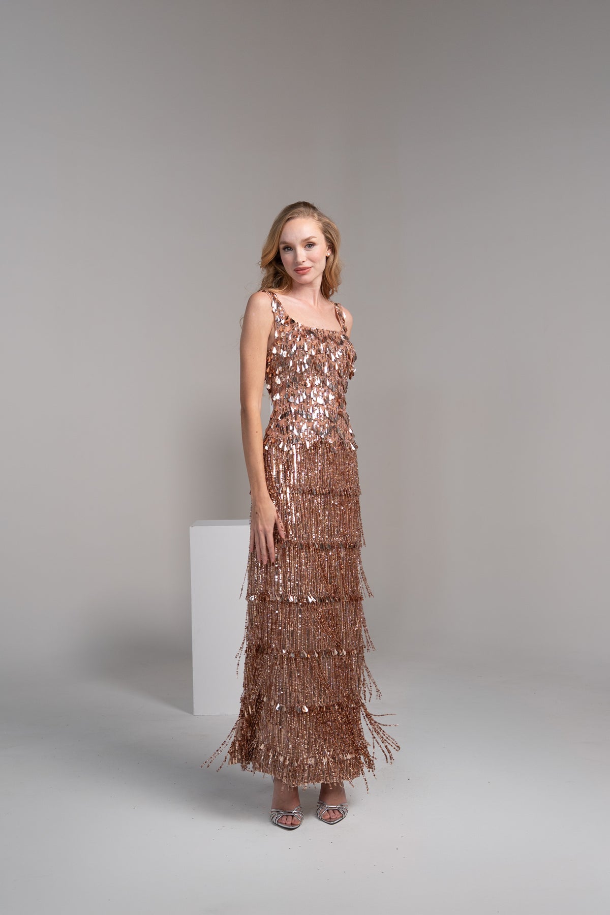 Rose gold dress featuring fringed detailing on the top and tassles on the skirt.