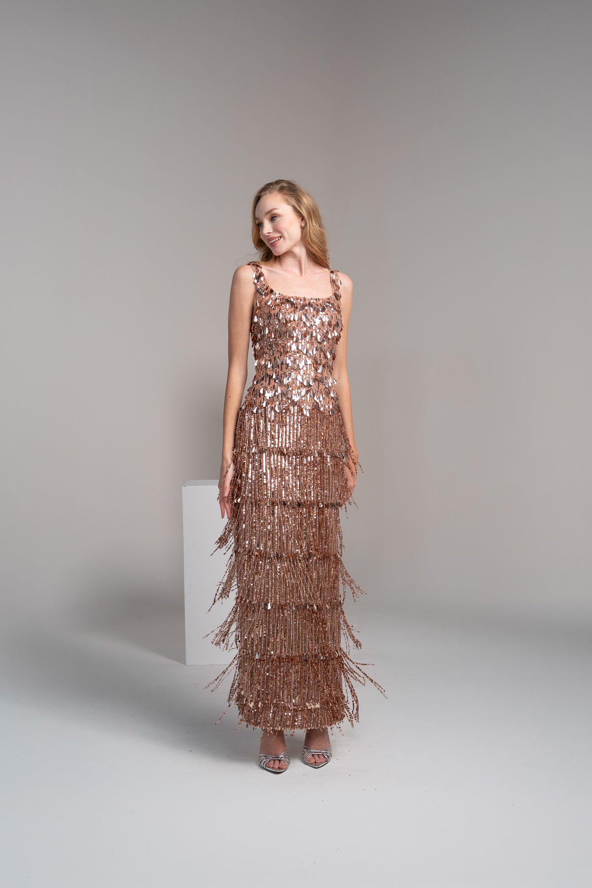 Rose gold dress featuring fringed detailing on the top and tassles on the skirt.