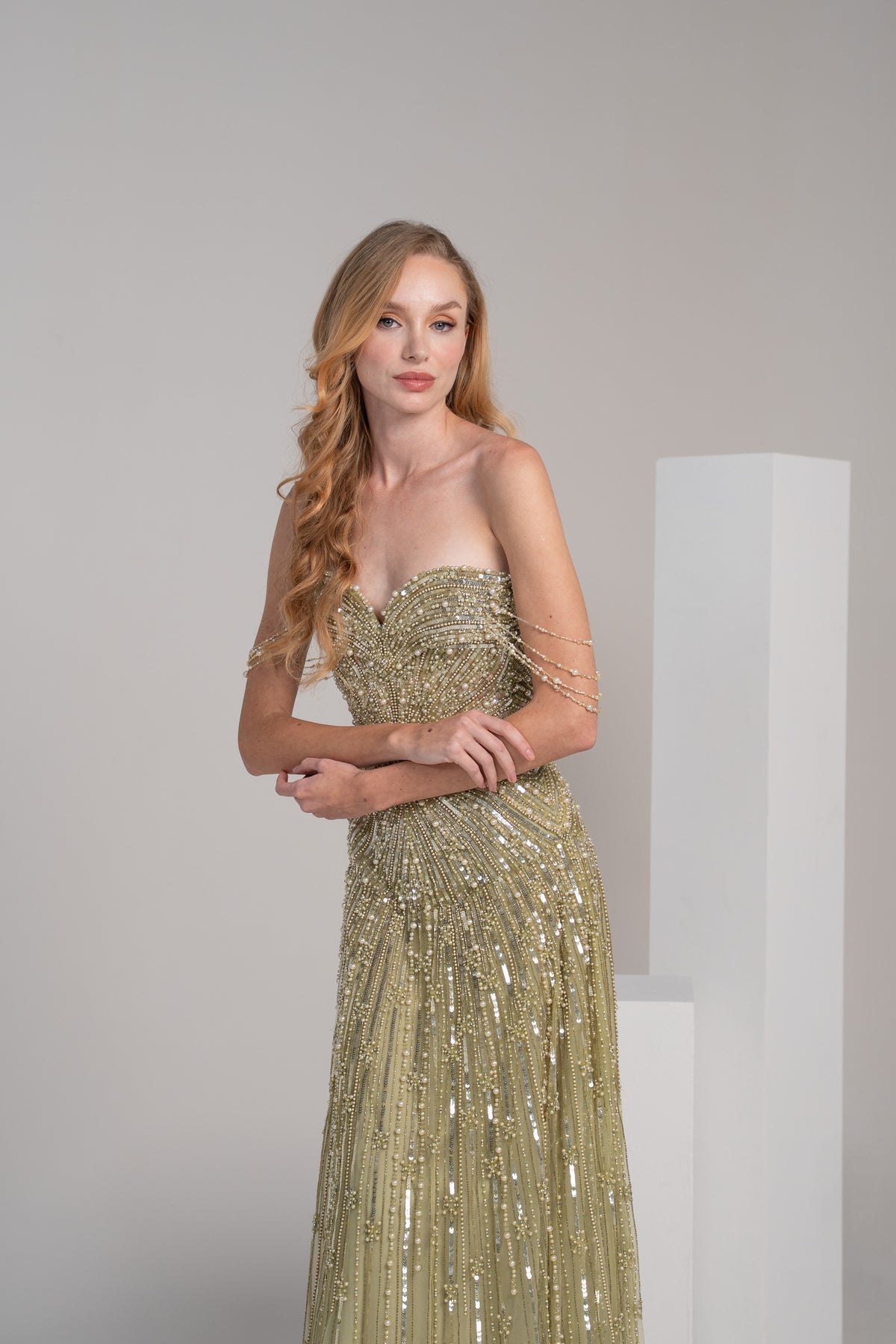 green fully beaded dress with pearl accents and embroidered lines on the skirt.
