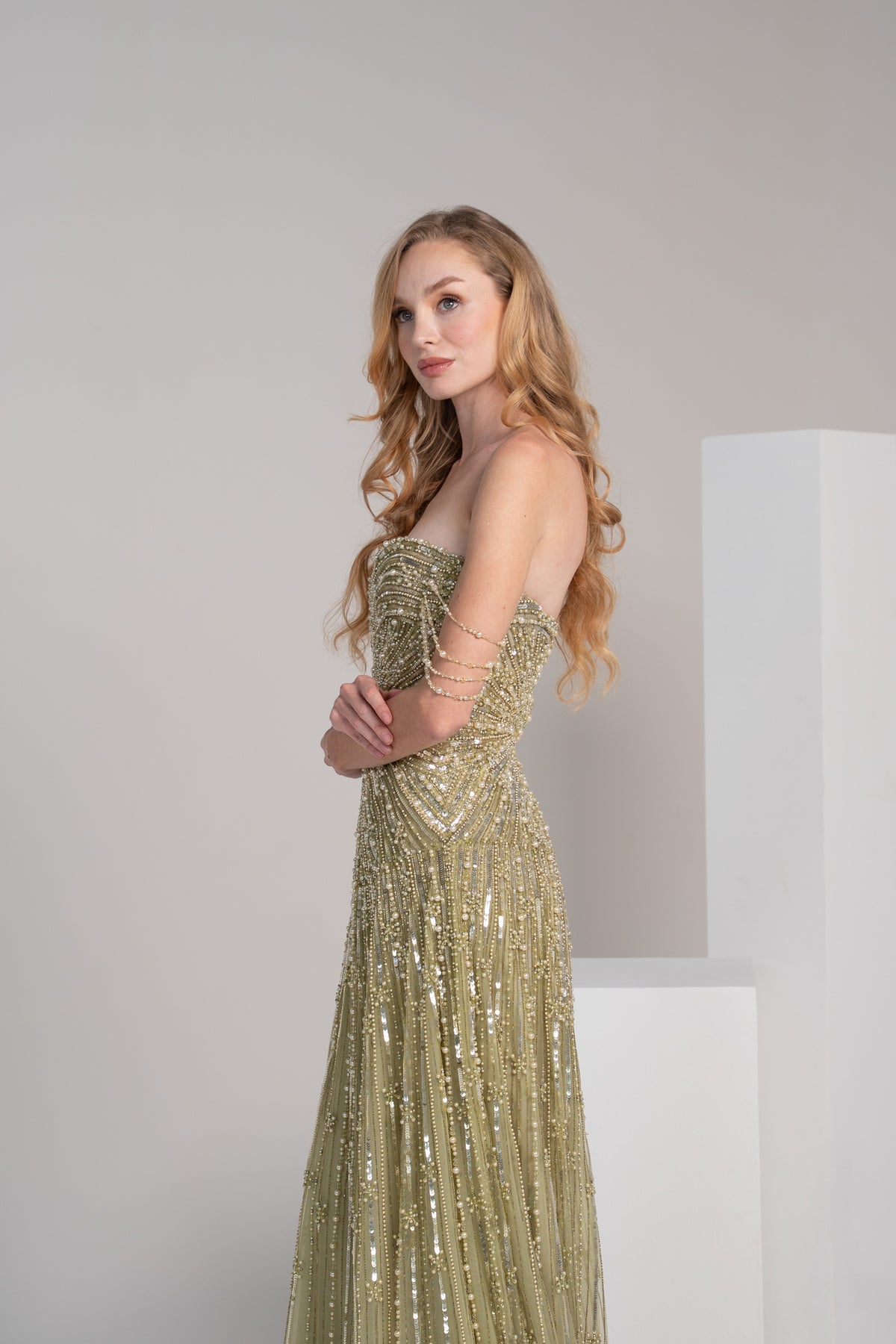 green fully beaded dress with pearl accents and embroidered lines on the skirt.